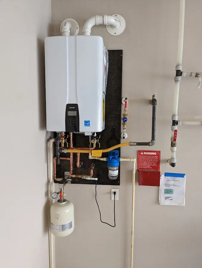 Professional plumber installing copper piping in a Glenmont home